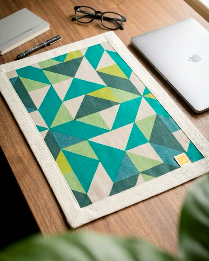 Angled view of green Mosaic placemat used as desktop mat