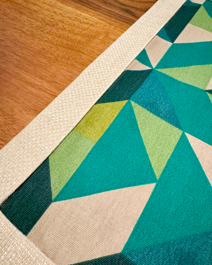 Close-up of Mosaic placemat corner with green geometric pattern and cotton linen texture