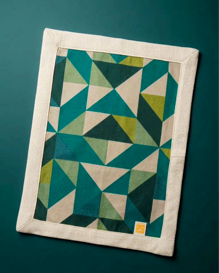 Mosaic placemat in green shades displayed on dark green background